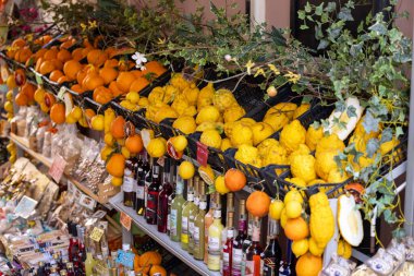 Taormina, Sicilya, İtalya - 28 Nisan 2023: Taze limon, portakal, şarap şişeleri ve geleneksel bölgesel ürünlerle dolu sokak yemekleri tezgahı