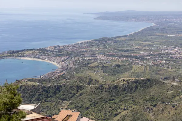 Castelmola, Sicilya, İtalya - 28 Nisan 2023: Mola Kalesi 'nden İyon Denizi körfezi üzerindeki Giardini Naxos kentinin havadan görünüşü.