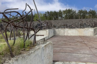 Belzec, Polonya - 29 Nisan 2025: Belzec Müzesi ve Anıtı, Nazi Alman imha kampı. Ohel Niche 'ye demir tellerle çevrili sembolik kömür yığınından Ölüm Yolu (Crevasse) görüntüsü