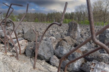Belzec, Polonya - 29 Nisan 2025: Belzec Müzesi ve Anıtı, Nazi Alman imha kampı. Paslı demir kablolarla çevrili beton duvar sembolik çöp yığınıyla çevrili.