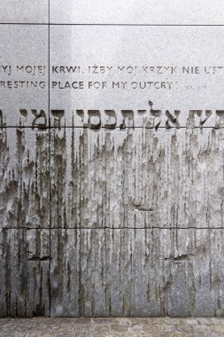 Belzec, Polonya - 29 Nisan 2025: Belzec Müzesi ve Anıtı, Nazi Alman imha kampı. Üç dilde Eyüp Kitabı 'ndan bir alıntı yapılmış granit duvar: Lehçe, İngilizce ve İbranice 