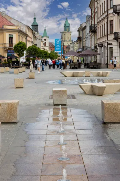 Lublin, Polonya - 24 Mayıs 2022: Krakowskie Przedmiescie Caddesi 'ndeki Mieczysaw Albert Krapec Meydanı' ndan bir sürü insan sokakta yürüyor. Trinitarian Kulesi ve Belediye Binası