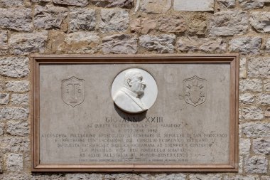 Assisi, İtalya - 12 Haziran 2025: Aşağı Plaza 'da görülen Assisi Aziz Francis Bazilikası Sacro Convento Manastırı' nın duvarında Papa 16.. 