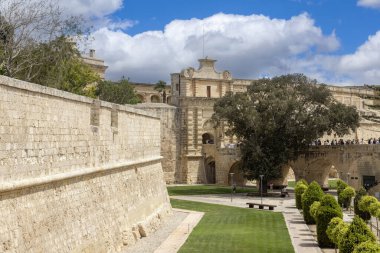 Malta, Mdina - 15 Nisan 2025: Barok Mdina Kapısı ve Ortaçağ Sessiz Şehri 'ni çevreleyen şehir duvarları. Tahkimatın etrafındaki güzel bahçeler