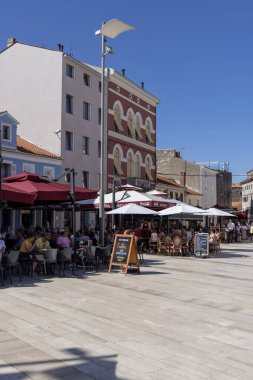 Porec, Hırvatistan, Istria - 25 Eylül 2023: Eski Kentin en büyük ve en popüler meydanı olan Özgürlük Meydanı 'ndaki İnsanlar (Trg Slobode)