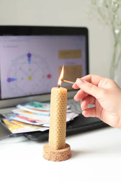 Kibritle bir mum yak. Esrarengiz bir uygulama. Ekranda Natal grafik ve arka planda tarot kartları 