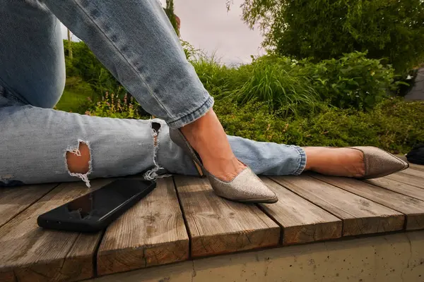 Yüksek topuklu ince kadın bacakları ve Pho 'lu otların yanında kot pantolon.