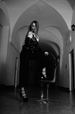 Binanın koridorunda kameraya poz veren güzel genç bir kadın.