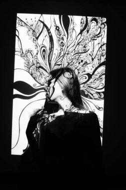 Güzel kadın bir süsün gölgesinde poz veriyor.