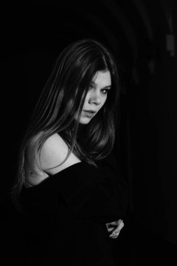 Binanın koridorunda kameraya poz veren güzel genç bir kadın.