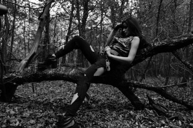 Ormanda savaşan bir kızın siyah-beyaz fotoğrafı.