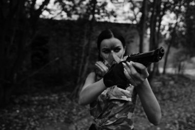 Ormanda savaşan bir kızın siyah-beyaz fotoğrafı.