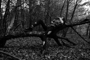 Ormanda savaşan bir kızın siyah-beyaz fotoğrafı.