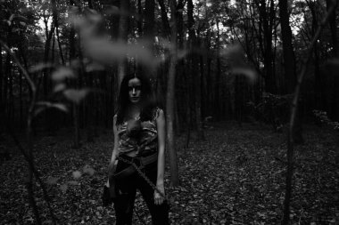 Ormanda savaşan bir kızın siyah-beyaz fotoğrafı.
