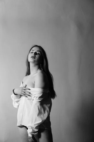 黒と白の写真美しい少女の白いシャツ1枚だけで彼女の裸の体の上に彼女のスタジオでポーズ — ストック写真