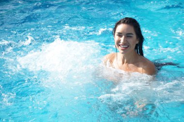 Yüzme havuzunda şeffaf elbiseli seksi bir kız.  