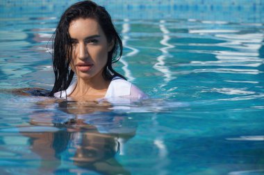 Yüzme havuzunda beyaz gömlekli seksi kız.  
