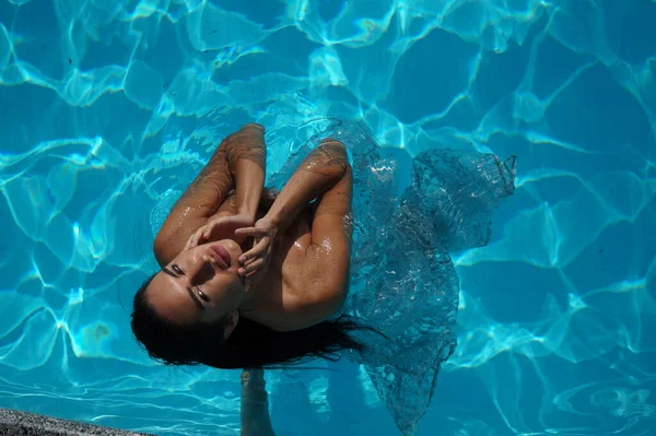 セクシーな女の子がプールで透明なドレスを着て — ストック写真