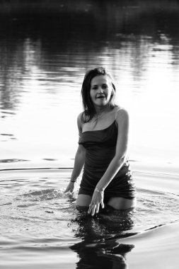 Parktaki gölde çekilmiş siyah beyaz bir kız fotoğrafı.