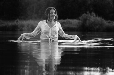 Parktaki gölde çekilmiş siyah beyaz bir kız fotoğrafı. ıslak saçlar ve elbiseler.