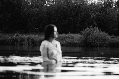 Parktaki gölde çekilmiş siyah beyaz bir kız fotoğrafı..   