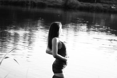 Parktaki gölde çekilmiş siyah beyaz bir kız fotoğrafı..   
