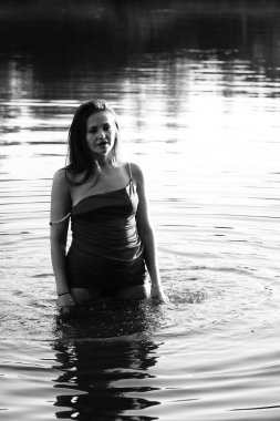 Parktaki gölde çekilmiş siyah beyaz bir kız fotoğrafı..   