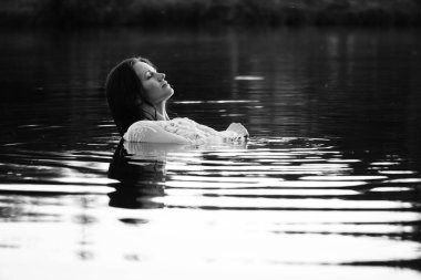Parktaki gölde çekilmiş siyah beyaz bir kız fotoğrafı..   