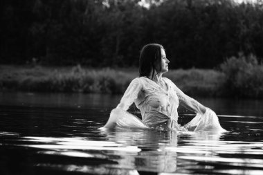 Parktaki gölde çekilmiş siyah beyaz bir kız fotoğrafı.