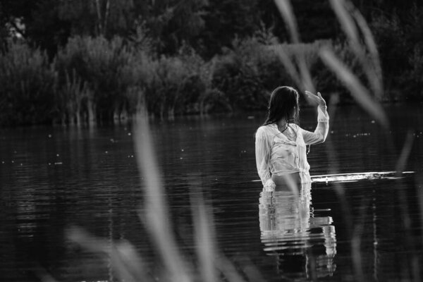 Black and white photo of a girl on a lake in the park
