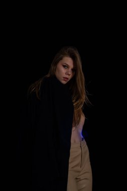 Stüdyoda poz veren güzel genç bir kadın.