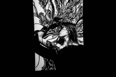 Bir süsün gölgesinde poz veren güzel bir kadın.