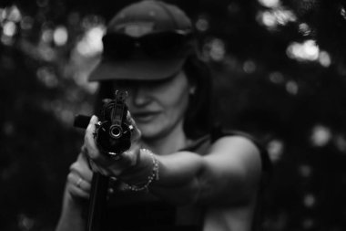 Ormanda yarı çıplak bir asker kızın siyah-beyaz fotoğrafı.