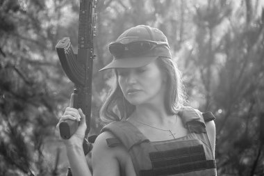 Ormanda yarı çıplak bir asker kızın siyah-beyaz fotoğrafı.