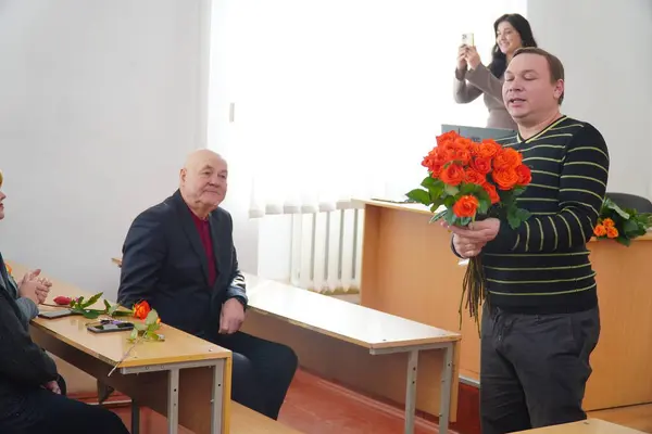 stock image Lutsk, Ukraine: man handing out tulips to women in award student ceremony on March 8 in Volyn Professional College of the National University of Food Technologies