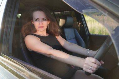 Kadın güzellik modeli arabada poz veriyor.