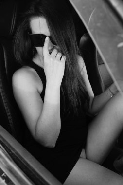 Kadın güzellik modeli arabada poz veriyor.