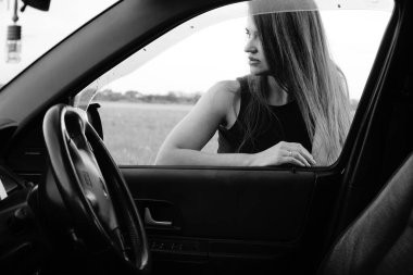 Kadın güzellik modeli arabada poz veriyor.