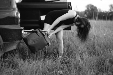 Güzel kız arabadan bir çanta çıkardı.
