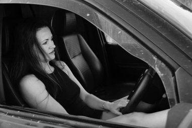 Kadın güzellik modeli arabada poz veriyor.