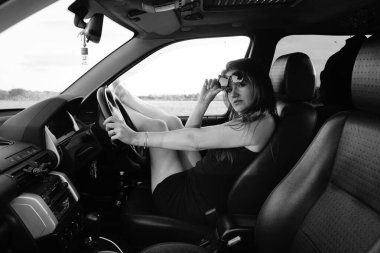 Kadın güzellik modeli arabada poz veriyor.