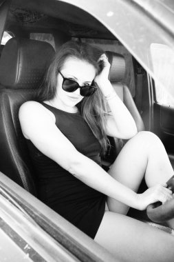 Kadın güzellik modeli arabada poz veriyor.