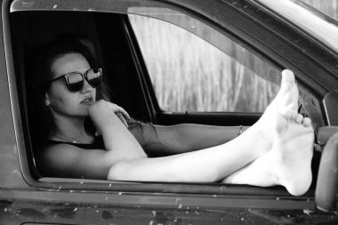 Kadın güzellik modeli arabada poz veriyor.