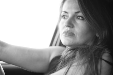 Kadın güzellik modeli arabada poz veriyor.