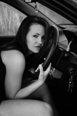 Kadın güzellik modeli arabada poz veriyor.