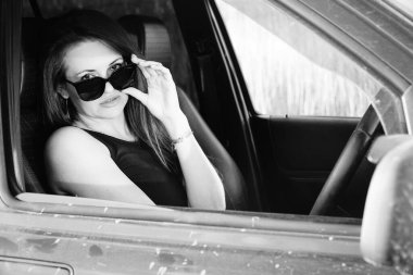 Kadın güzellik modeli arabada poz veriyor.