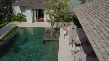 Moda adamı model yürüyüşüyle havuz boyunca yürür.