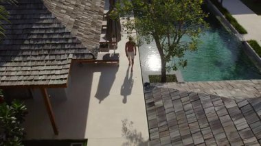 Moda adamı model yürüyüşüyle havuz boyunca yürür.