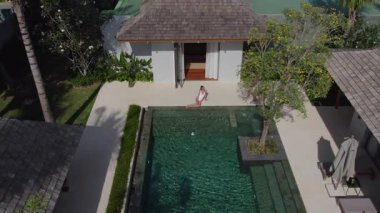 Lüks bir villada havuz başında oturan bir kız, sportif bir adam ona gelir.