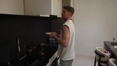 Mutfakta yemek yapmaya hazırlanan bir çift raflarda malzeme arıyor. Evdeki samimi ve neşeli bir an..